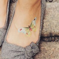 Jasny motyl tatuaż na stopie