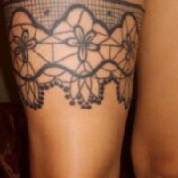 Koronkowa podwiązka tatuaż na udzie