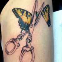 Nożyce rozcinające motyla tatuaż