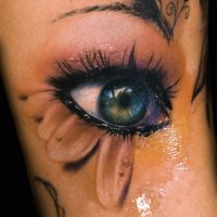 Oko z płatkami kwiatu tatuaż