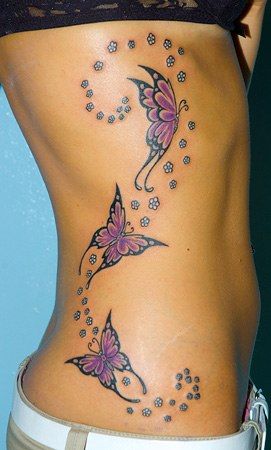 Trzy różowe motyle i kwiaty tatuaż